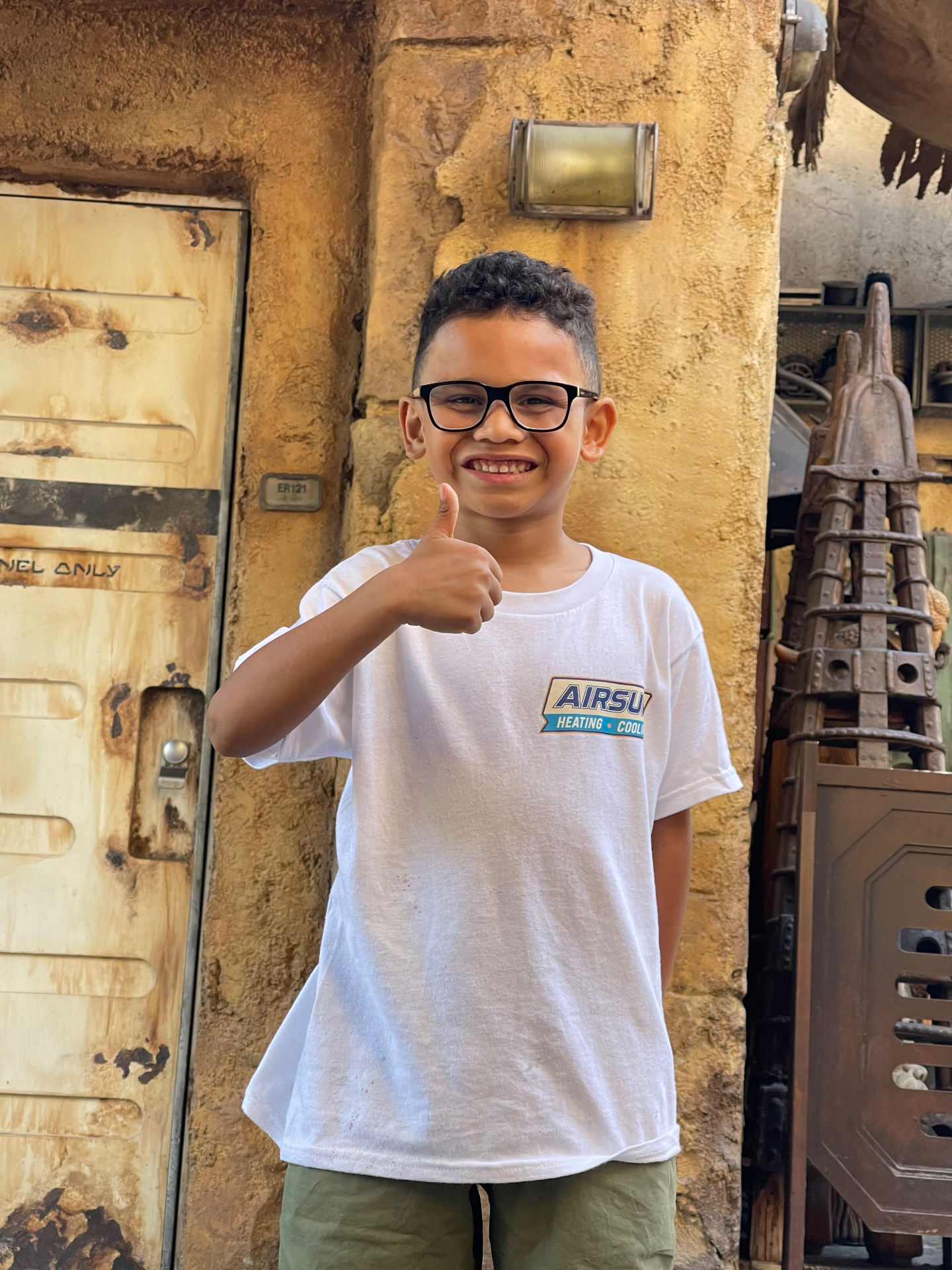 Airsun family member wearing an Airsun Heating & Cooling shirt and giving a thumbs up