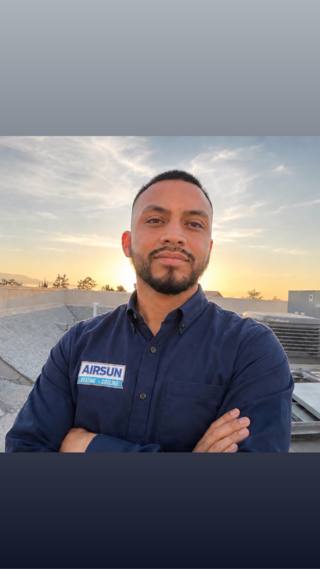 Airsun Heating & Cooling technician in uniform on a rooftop at sunset